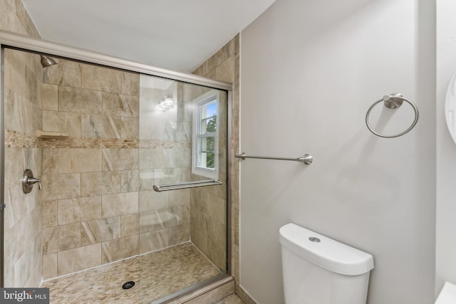 bathroom with toilet and an enclosed shower