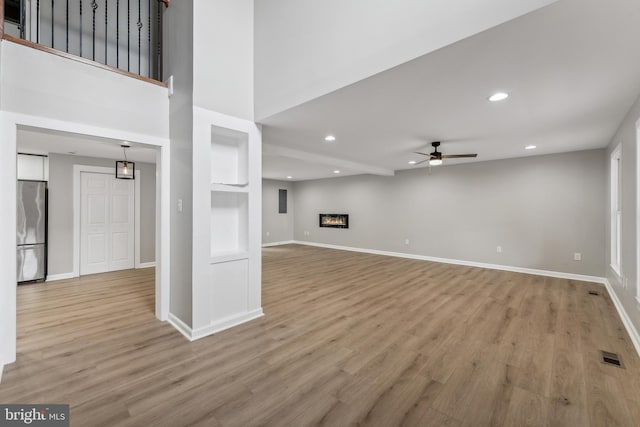 unfurnished living room with ceiling fan and hardwood / wood-style floors