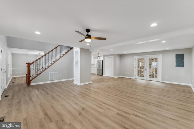 unfurnished living room with light wood-type flooring, french doors, ceiling fan, and electric panel