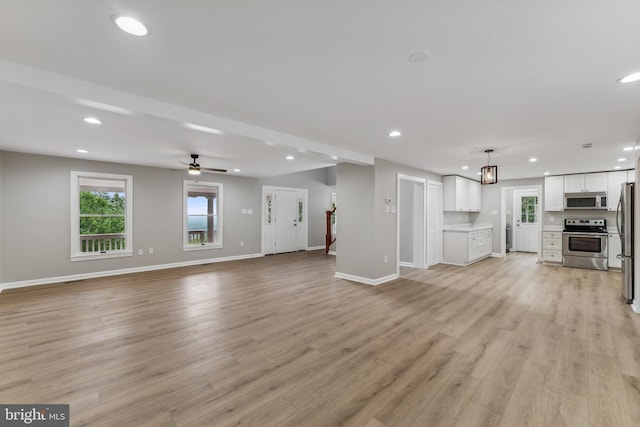 unfurnished living room featuring light hardwood / wood-style floors and ceiling fan