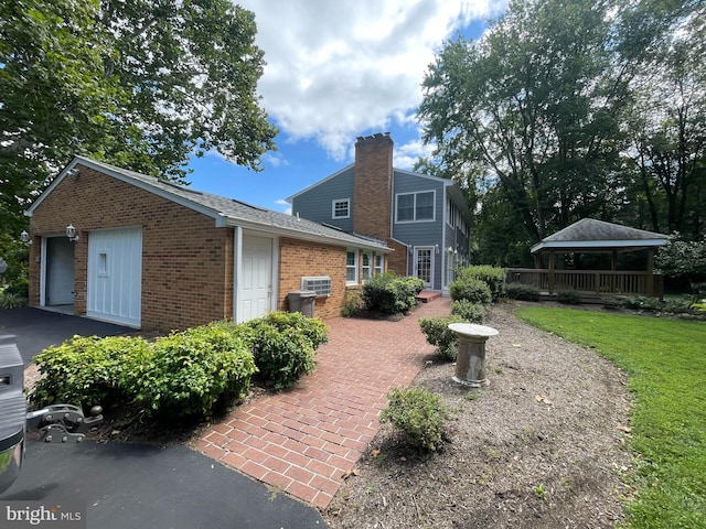 rear view of house featuring a gazebo and a lawn