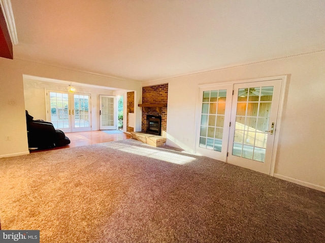 unfurnished living room featuring french doors, carpet flooring, and a fireplace