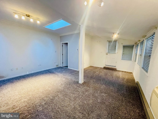 carpeted spare room with rail lighting, crown molding, and vaulted ceiling with skylight