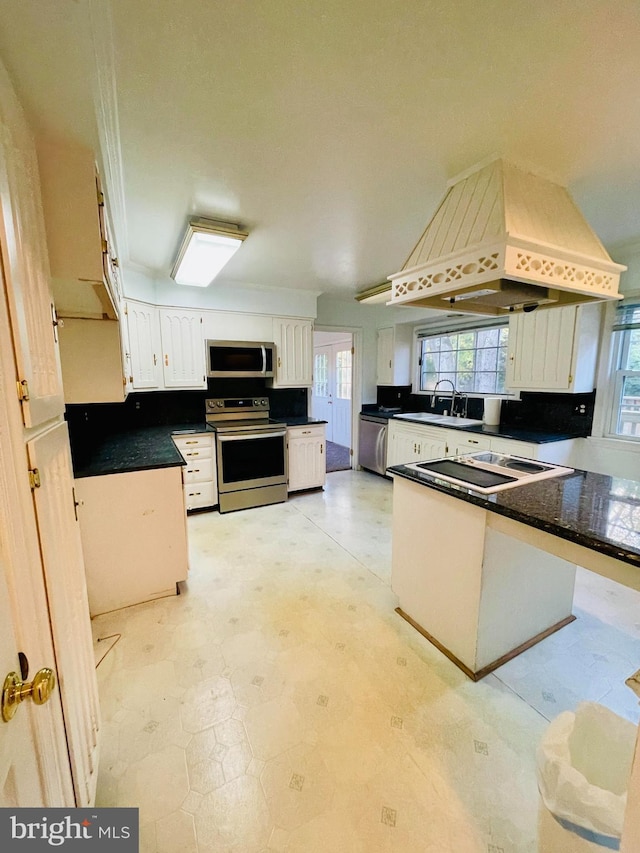 kitchen featuring appliances with stainless steel finishes, sink, kitchen peninsula, white cabinets, and premium range hood