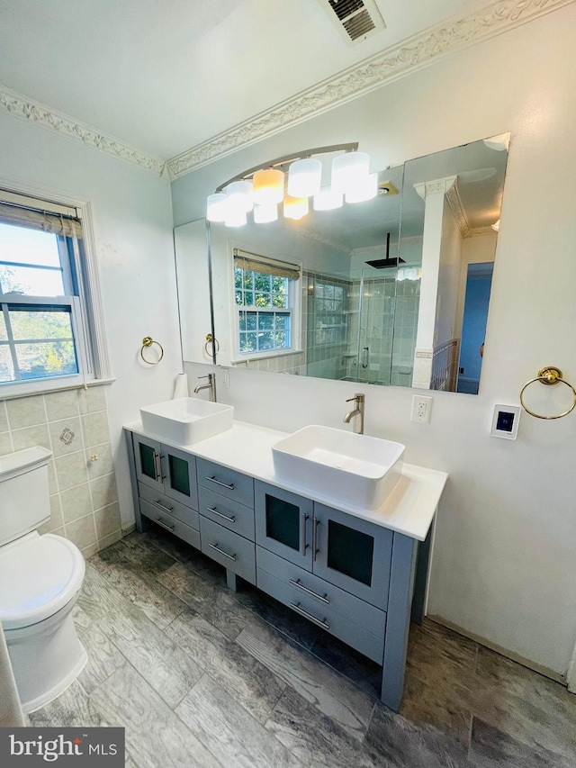 bathroom with vanity, an enclosed shower, toilet, and crown molding