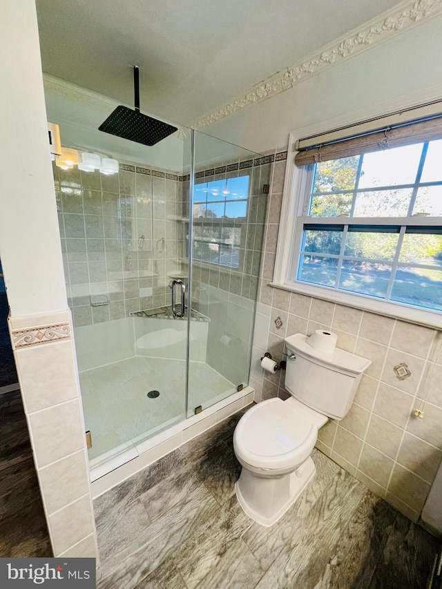 bathroom with toilet, tile walls, and an enclosed shower