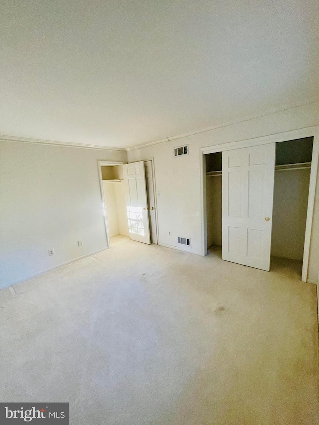 unfurnished bedroom featuring light carpet and crown molding