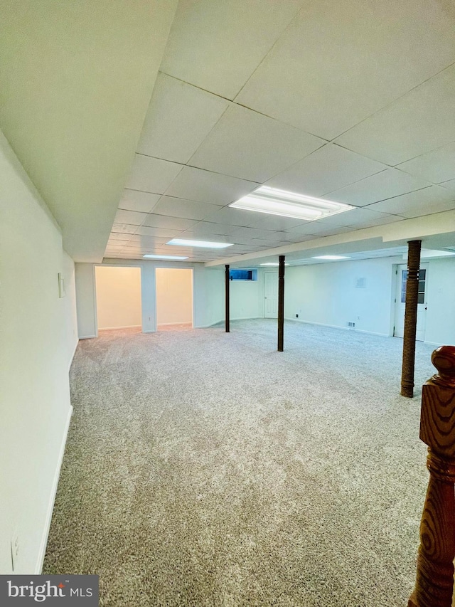 basement featuring carpet flooring and a paneled ceiling