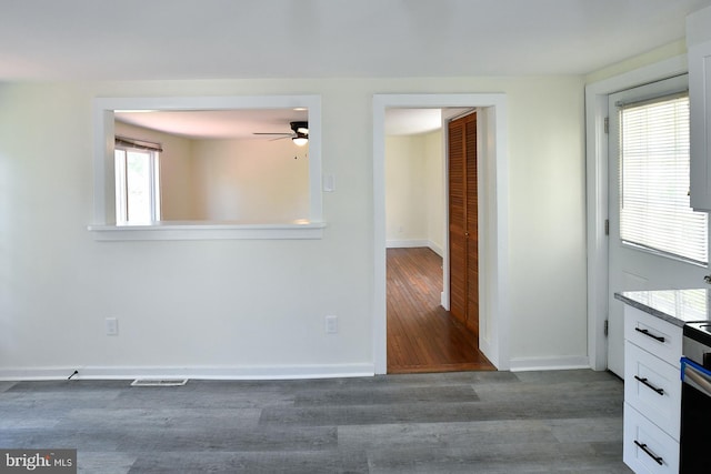 unfurnished room featuring dark hardwood / wood-style flooring, a healthy amount of sunlight, and ceiling fan