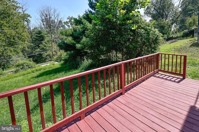 wooden terrace featuring a lawn