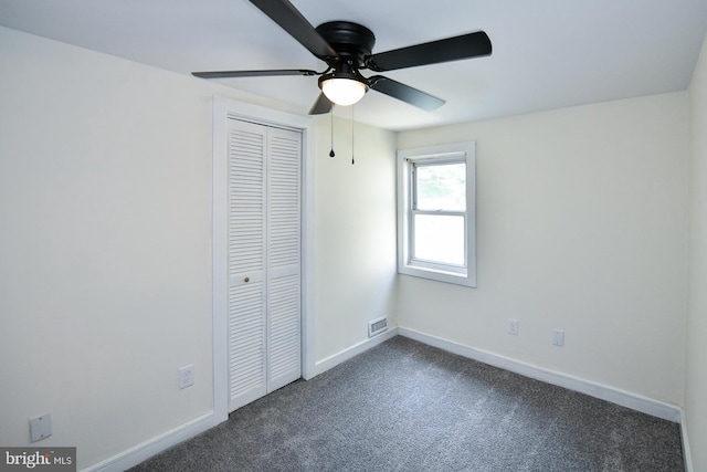 unfurnished bedroom with carpet flooring, ceiling fan, and a closet