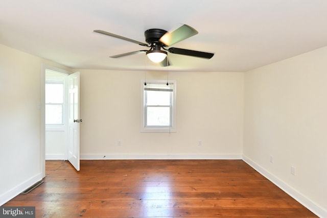 spare room with a wealth of natural light, hardwood / wood-style floors, and ceiling fan