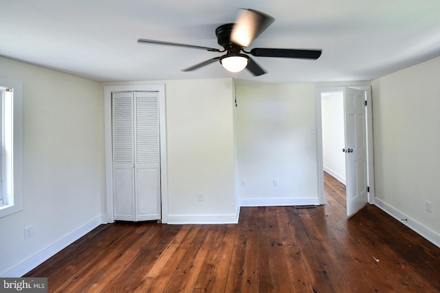 unfurnished bedroom featuring ceiling fan, dark hardwood / wood-style floors, and a closet