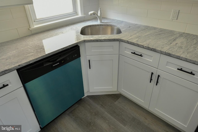 kitchen with dark wood-type flooring, white cabinets, tasteful backsplash, and stainless steel dishwasher