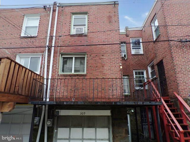 rear view of house featuring brick siding and an attached garage