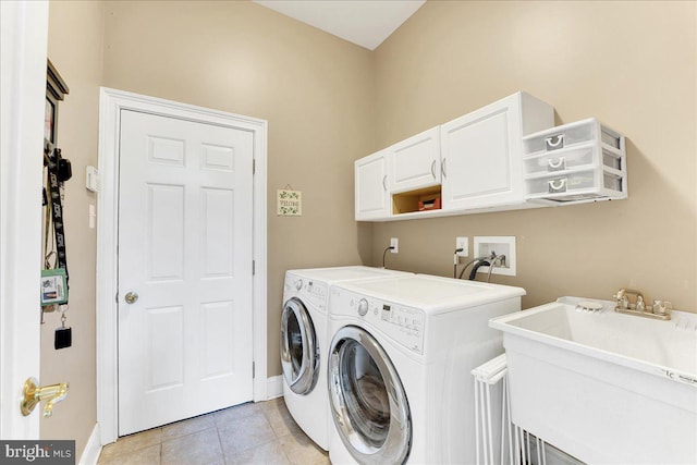 washroom featuring cabinets, light tile patterned flooring, washer and dryer, and sink