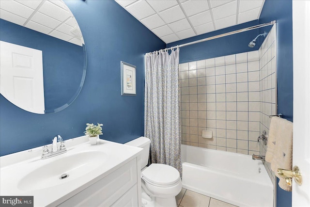 full bathroom with tile patterned flooring, a drop ceiling, shower / tub combo, vanity, and toilet