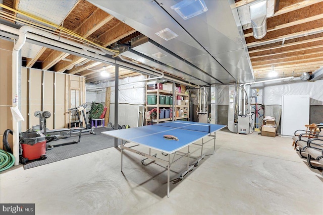 recreation room featuring heating unit and concrete floors