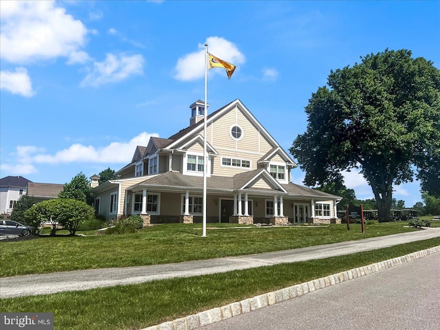 view of front of home featuring covered porch and a front yard