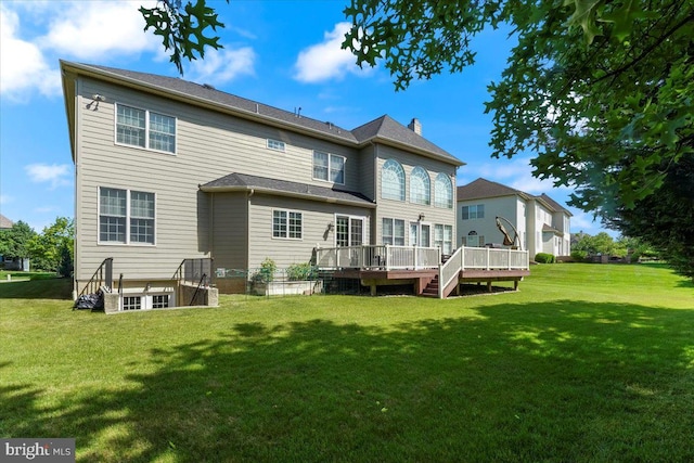 rear view of house with a wooden deck and a yard