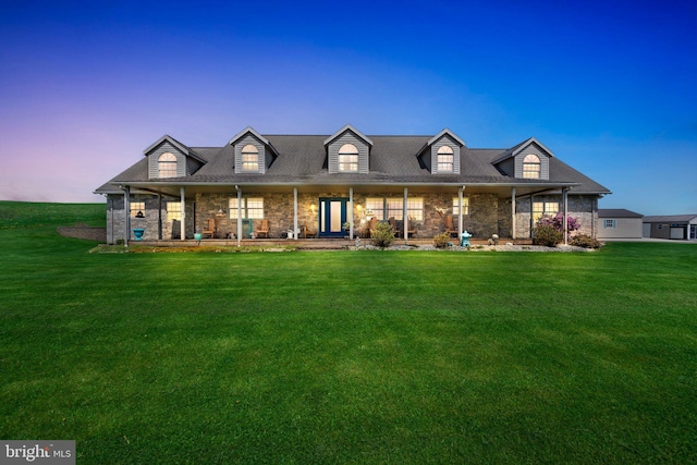 new england style home featuring a front yard and covered porch