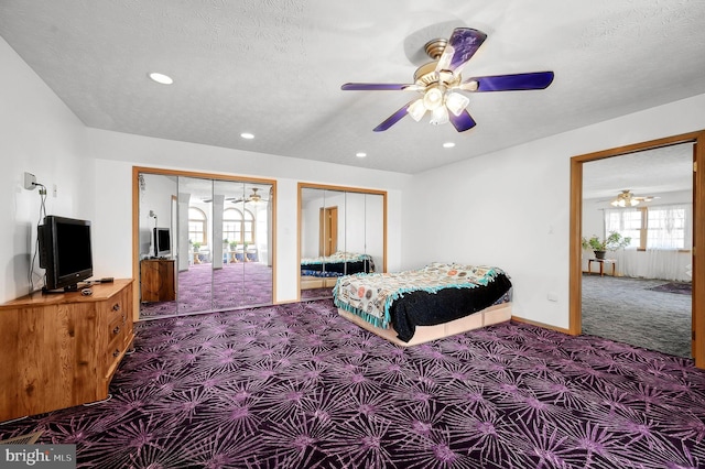 bedroom with a textured ceiling, carpet flooring, two closets, and recessed lighting