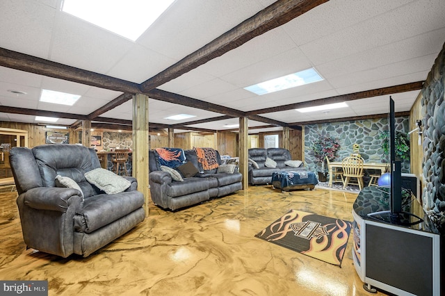 living room featuring wooden walls and a drop ceiling