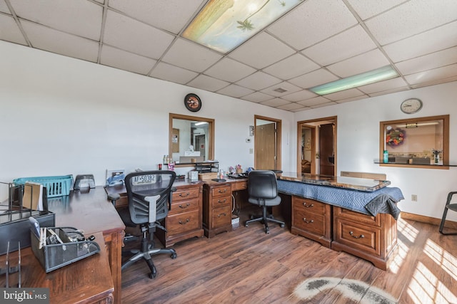 office with a paneled ceiling, baseboards, and wood finished floors