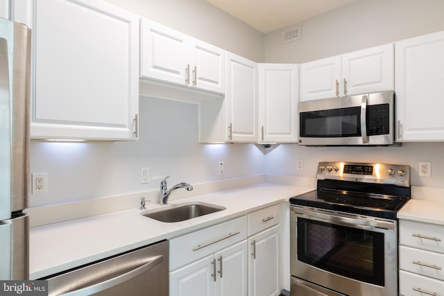 kitchen with visible vents, a sink, white cabinetry, appliances with stainless steel finishes, and light countertops