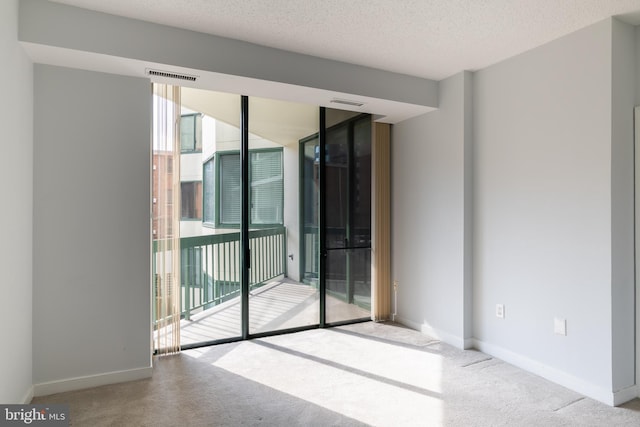 carpeted empty room featuring a textured ceiling