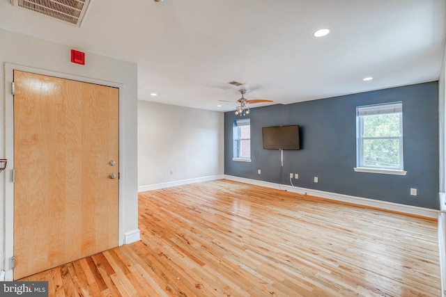 spare room with light wood-type flooring, plenty of natural light, and ceiling fan