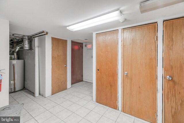 hallway featuring gas water heater and light tile patterned floors