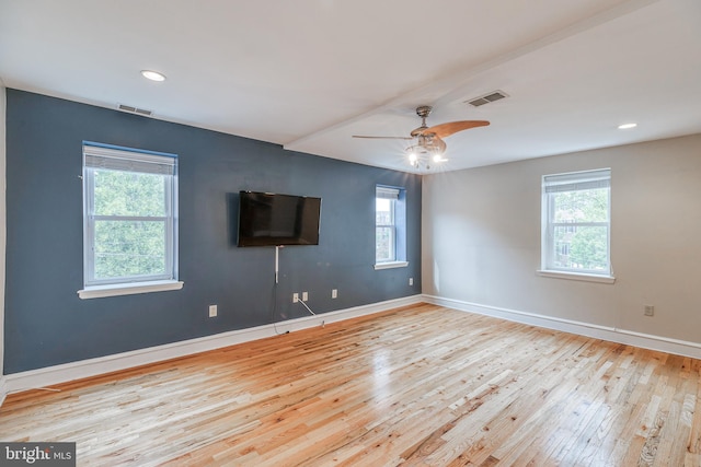 spare room with plenty of natural light, ceiling fan, and light wood-type flooring