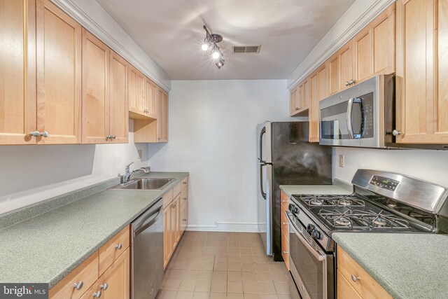 kitchen featuring light tile patterned floors, appliances with stainless steel finishes, light brown cabinets, and sink