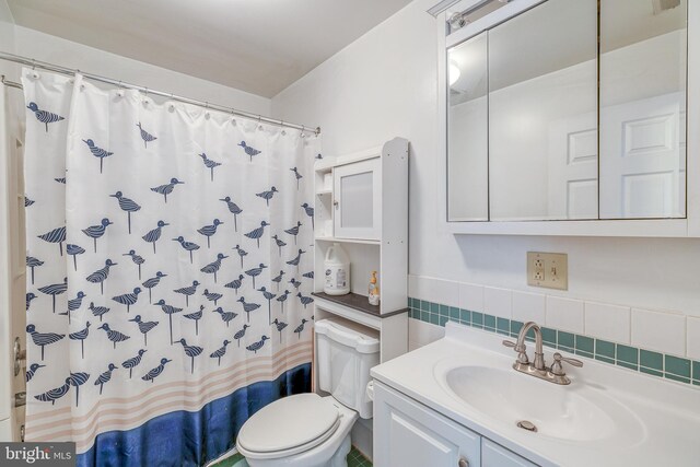 bathroom with curtained shower, backsplash, toilet, and vanity