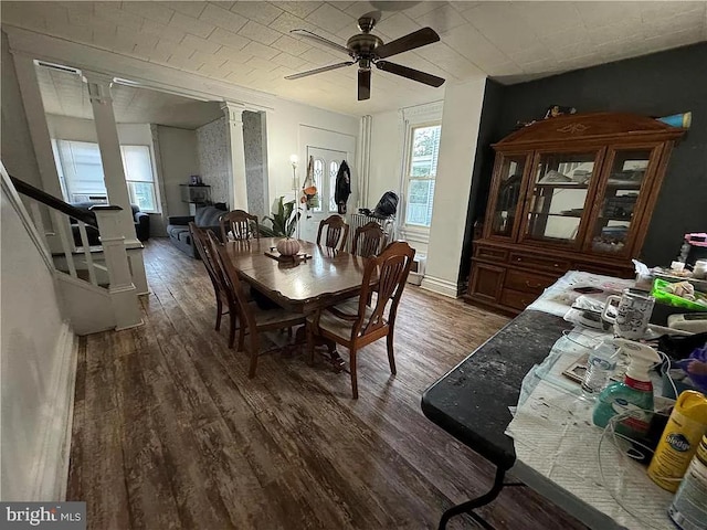 dining space featuring ornate columns, ceiling fan, and dark hardwood / wood-style floors