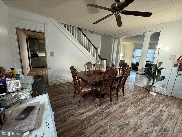 dining room featuring dark wood-type flooring, decorative columns, and ceiling fan