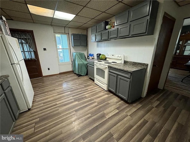 kitchen with dark wood-type flooring, white appliances, gray cabinetry, and a drop ceiling