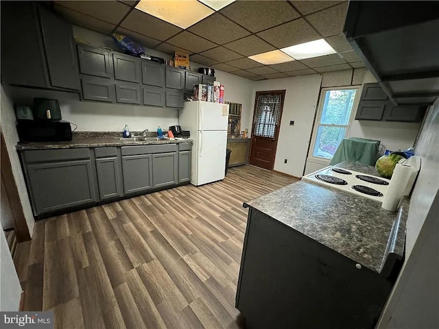 kitchen featuring a paneled ceiling, white fridge, and light wood-type flooring