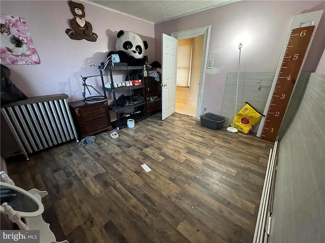 bedroom featuring crown molding and dark wood-type flooring