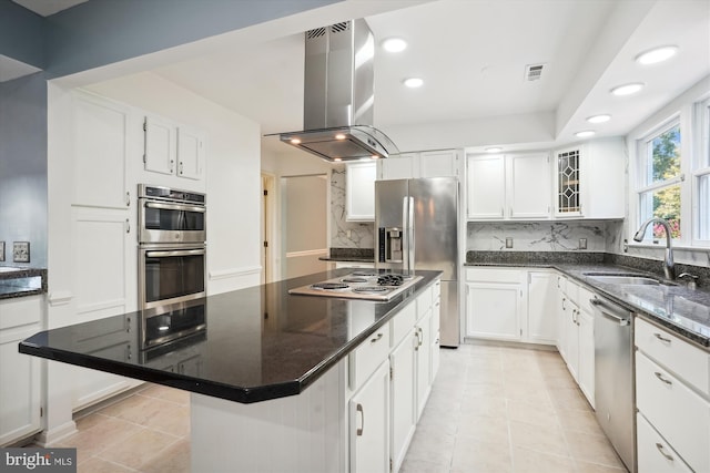 kitchen featuring a sink, decorative backsplash, white cabinets, appliances with stainless steel finishes, and island range hood