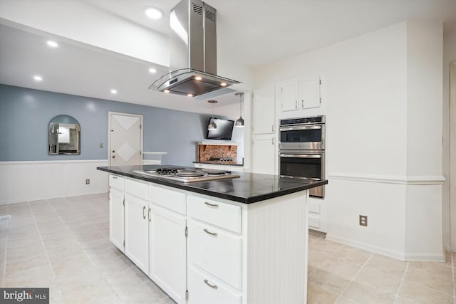 kitchen featuring island exhaust hood, dark countertops, appliances with stainless steel finishes, and white cabinets