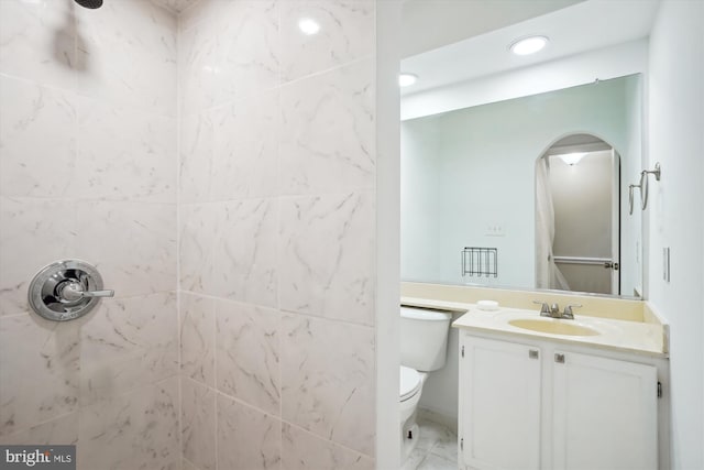 full bath featuring marble finish floor, toilet, tiled shower, and vanity