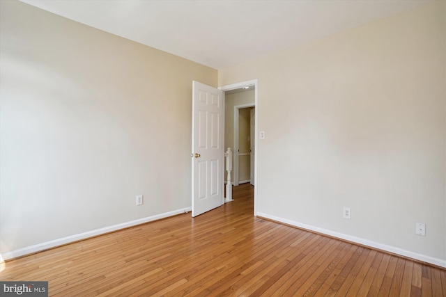 empty room with baseboards and light wood finished floors