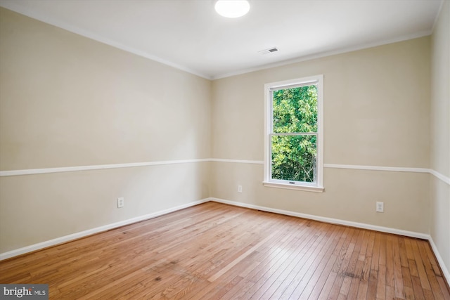 spare room featuring visible vents, baseboards, hardwood / wood-style floors, and ornamental molding