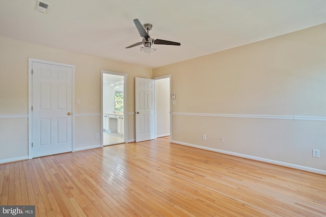 unfurnished bedroom with visible vents, baseboards, connected bathroom, and light wood finished floors