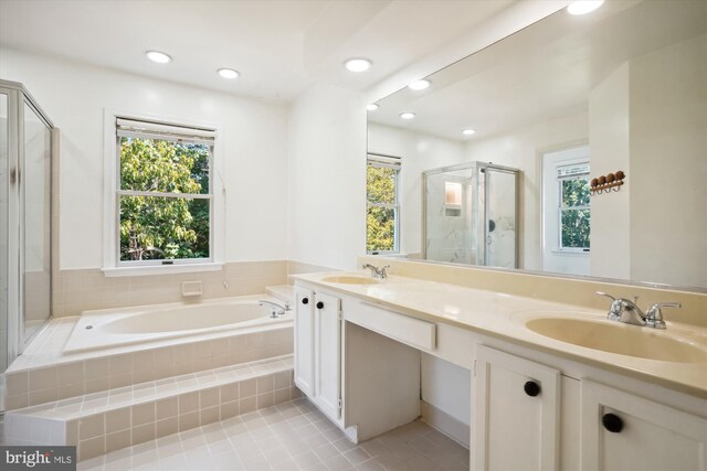 bathroom with a sink, a garden tub, double vanity, and a shower stall