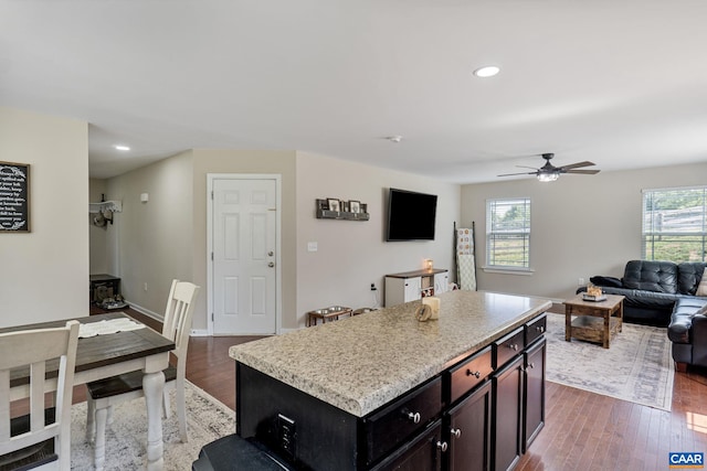 kitchen featuring a kitchen island, ceiling fan, and hardwood / wood-style flooring