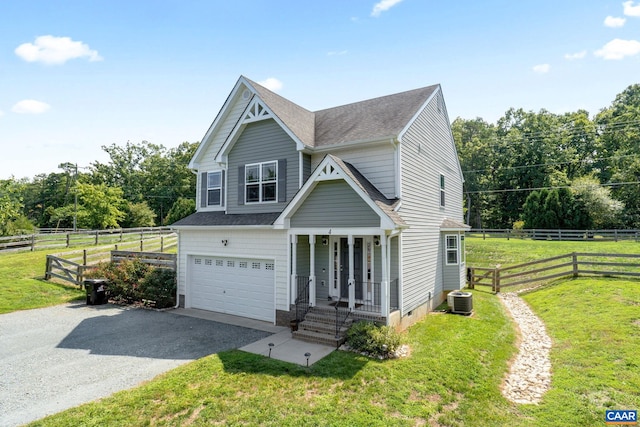 view of front facade with a garage, a rural view, central AC, and a front yard