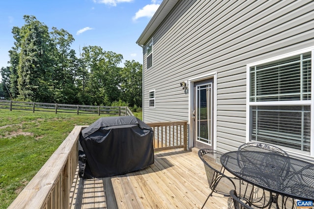 wooden deck with a yard and grilling area